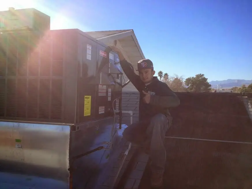 HVAC technician performing HVAC Inspection on a rooftop unit in Dunbar
